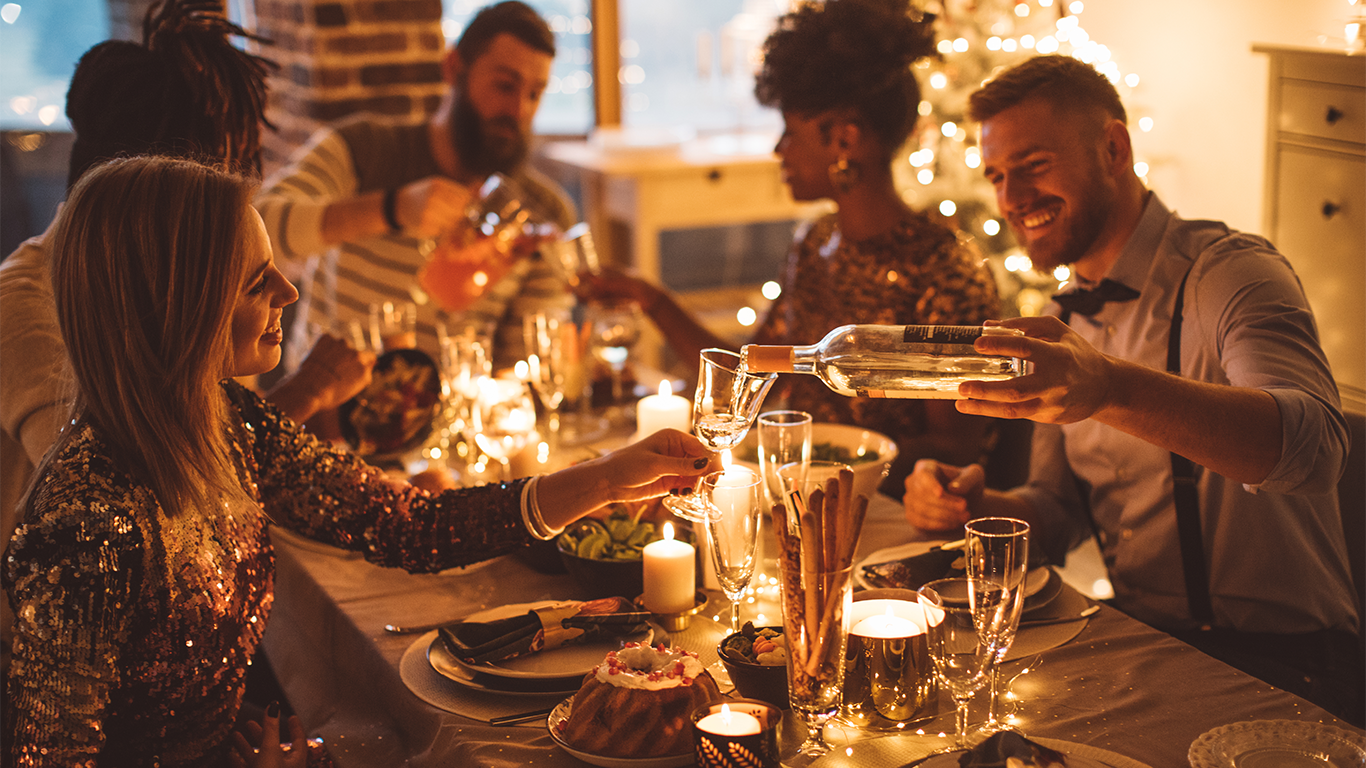 Venner som spiser god mat rundt et dekket julebord